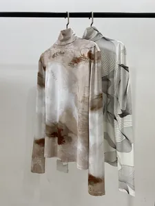 Détail de hauts à manches longues et col montant avec imprimés marbrés et abstraits