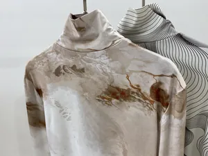 Détail de hauts à col roulé ajustés avec imprimés marbre et vagues en tissu soyeux