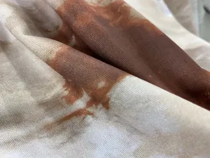 Vue macro montrant la texture en maille douce et le motif marbré brun du haut à manches