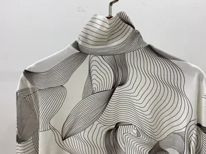 Gros plan détaillé du col roulé haut avec des motifs de lignes ondulées noires abstraites