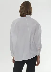 Rear view detail of minimalist white oversized cotton shirt with asymmetrical back stitching