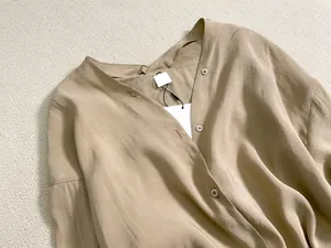 Détail d'une robe chemise kaki à col en V avec boutons et texture de tissu délicate