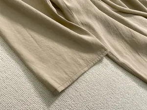 Détails du tissu en lin marron clair et des finitions de couture sur le bas du pantalon