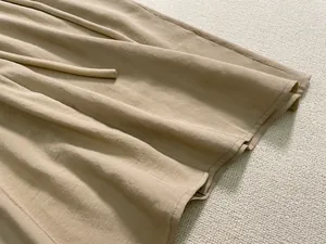 Détail d'une robe marron clair montrant la texture du lin et le cordon de serrage