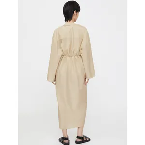 Vue arrière d'une robe chemise beige à manches longues avec cordon de serrage à la taille