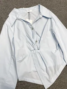 Detail view of light blue shirt featuring a unique twist knot design and cotton texture