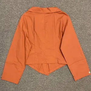 Rear view of a minimalist orange long-sleeve blouse with a structured turn-down collar