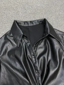 Detail of black faux leather shirt collar and smooth texture with round buttons