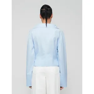 Light blue long-sleeved shirt with wide collar and slim waist design shown from the back