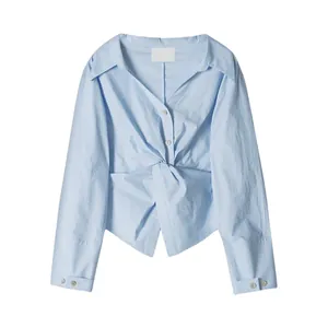 Light blue long sleeve twisted knot shirt with irregular design and white buttons