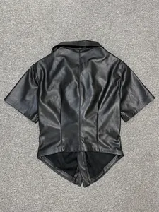 Detail of a matte black faux leather shirt featuring a pointed fishtail hem and V-neckline
