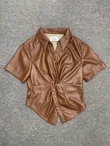 Detail view of the twisted waist knot and high-quality leather texture on brown shirt