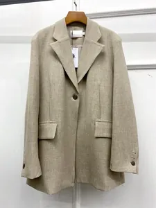 Detailed view of oatmeal blazer texture with notched lapel and flap pockets