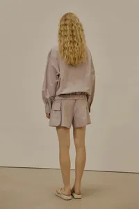 Back view of minimalist long-sleeve hooded jacket and cargo shorts set in dusty pink