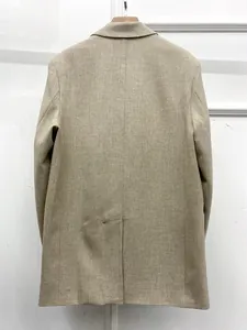 Macro shot of the linen-texture fabric and central back vent on a beige casual blazer