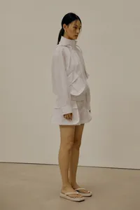 Detail of white hooded jacket with large utility pockets and adjustable drawstrings