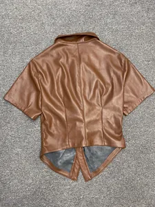 Detail view of the deep brown faux leather shirt featuring a unique split pointed hemline