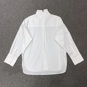 Detail of white oversized shirt showing high stand collar and back box pleat design