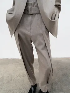 Detail of high-waist wide-leg trousers in taupe with matching belt and square buckle