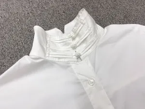 Detail of a white mandarin collar shirt with traditional Chinese frog button fasteners