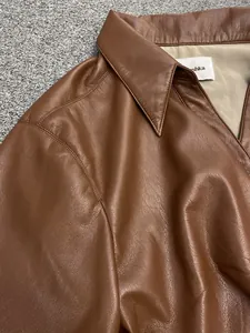 Close-up of the brown leather shirt collar showing detailed texture and refined stitching