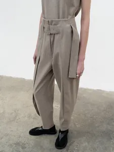 Detail of high-waist trousers with a matching wide belt and metallic buckle detail