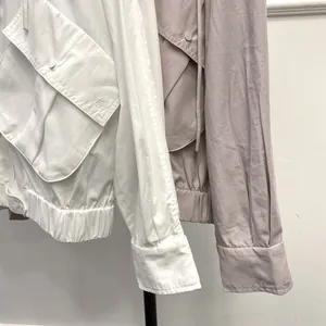 Detail of cargo-style jacket pockets with button flaps and refined embroidery stitching