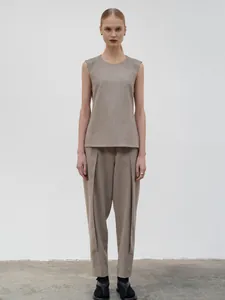 Detail of high-waist pleated trousers with textured fabric and matching sleeveless top