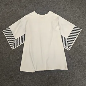 Detail of loose fit cotton T-shirt with oversized striped sleeves and round neckline