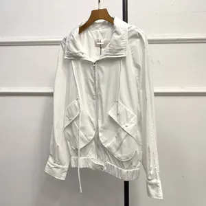 Detail of white hooded jacket showing large flap pockets and elastic hem design