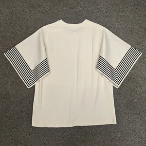Detail of minimalist cream t-shirt with geometric black stripe patterns on the short sleeves
