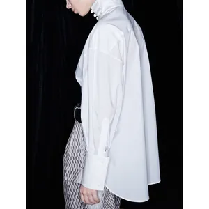 Oversized white long sleeve blouse with stand collar and buttons in minimalist style