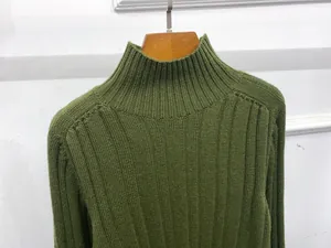 Detail of army green rib-knit high collar sweater showing vertical textured fabric on a hanger