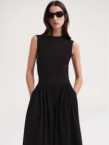 Robe mi-longue noire sans manches avec col rond et taille cintrée au style épuré