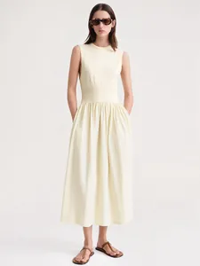 Détail d'une robe midi sans manches jaune clair avec taille ajustée et jupe plissée en A