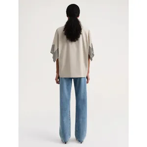 Minimalist beige loose cotton T-shirt with striped cuffs and blue wide-leg jeans