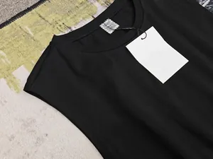 Détail à plat d'une robe sans manches noire à col rond avec étiquette blanche et tissu coton