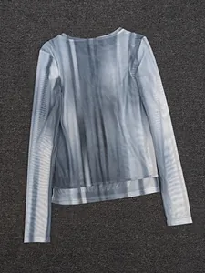Close-up of the breathable grey and white gradient mesh fabric on a long sleeve crewneck top
