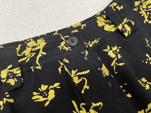 Detail view of high-waist floral midi skirt with black buttons and yellow flower pattern