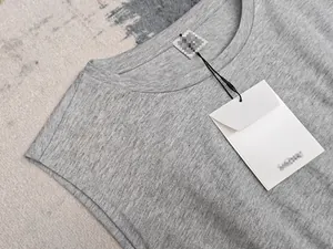 Détail de l'encolure de la robe grise sans manches avec étiquette en tissu et carton