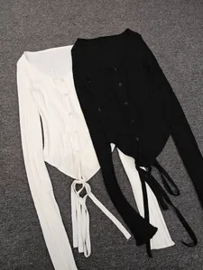 Detailed flat lay of black and white ribbed knit cardigans with asymmetric hem and long ties