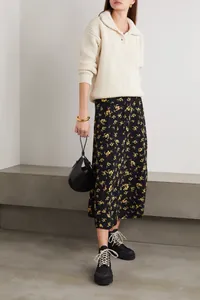 Detail of high waist midi floral skirt paired with a cream-white knit sweater