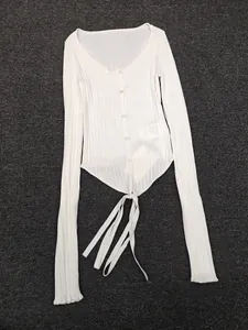 Detail of ivory long sleeve rib knit cardigan showing lace-up hem and button closure