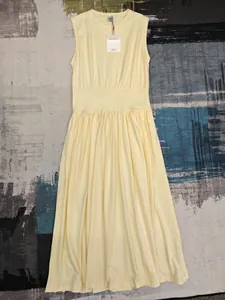 Détail de robe jaune clair sans manches avec taille cintrée et jupe plissée fluide