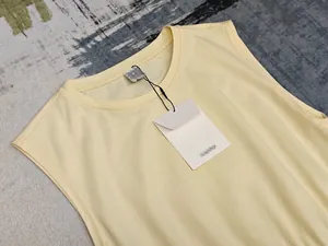 Gros plan d'une robe sans manches jaune pâle minimaliste avec encolure ronde et coton doux