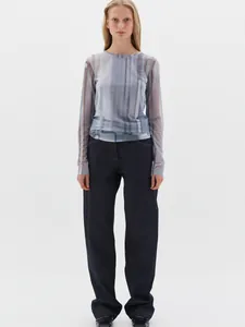 Close-up of a blue striped sheer mesh long-sleeve top paired with wide-leg denim jeans
