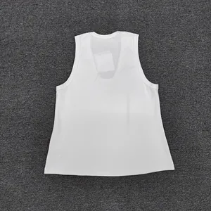 Detailed flat lay of white sleeveless cotton vest with round neck on grey background