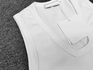 Close-up of a white V-neck sleeveless top showing the neckline stitching and brand label