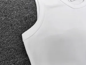 Detailed close-up of high-quality double-needle stitching on white sleeveless tank top