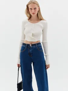 Close-up of cream ribbed knit cardigan with button-down front and crew neck finish